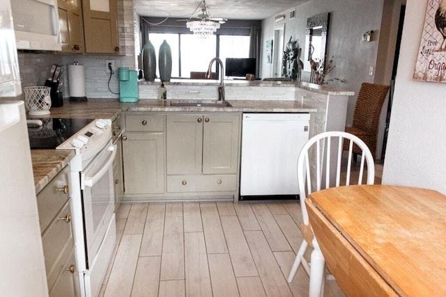 kitchen with white appliances, sink, light hardwood / wood-style flooring, tasteful backsplash, and a notable chandelier