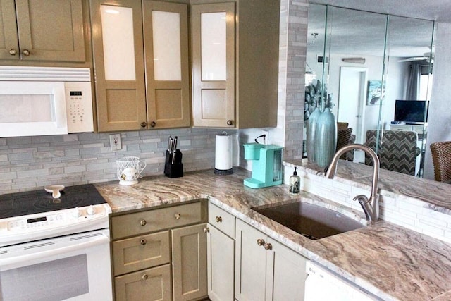 kitchen with white appliances, light stone counters, ceiling fan, and sink