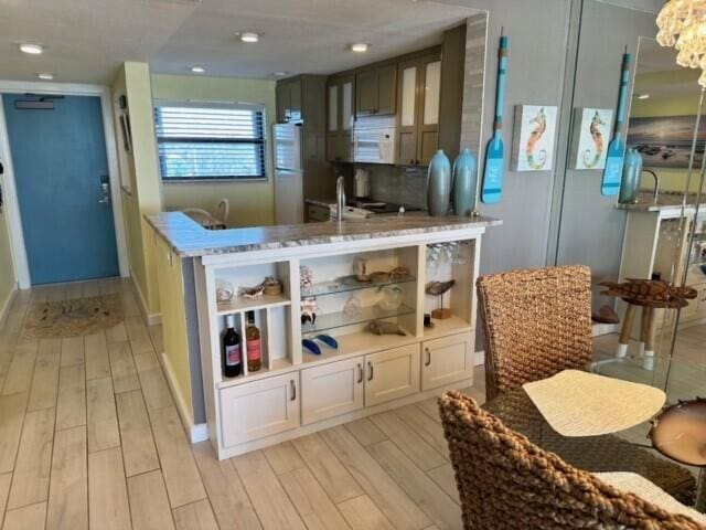 kitchen featuring white appliances, white cabinets, light hardwood / wood-style floors, and sink