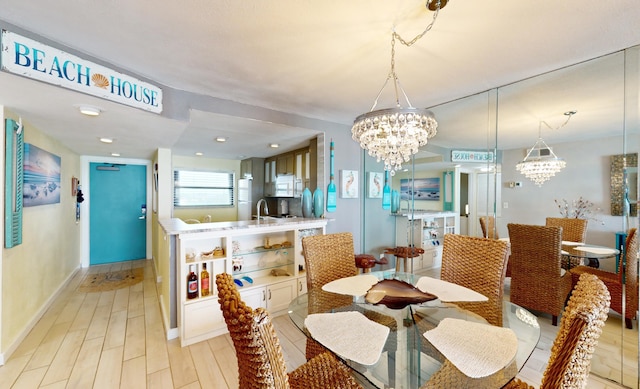 dining room with light hardwood / wood-style floors, sink, and a chandelier