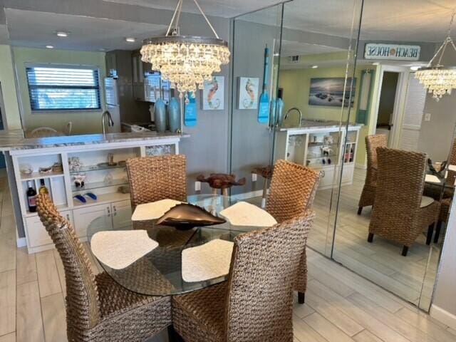 dining area with an inviting chandelier and light hardwood / wood-style flooring