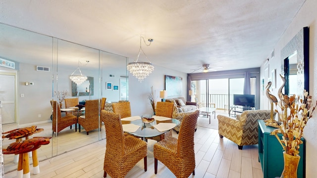 dining room featuring light hardwood / wood-style floors and ceiling fan with notable chandelier