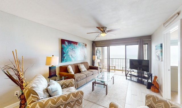 living room with ceiling fan, a wealth of natural light, and light hardwood / wood-style flooring