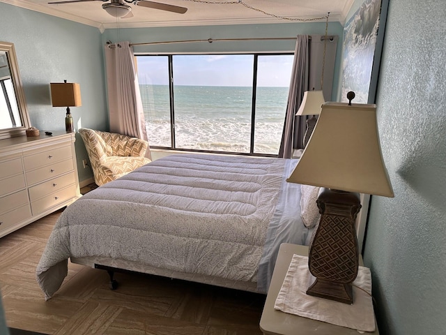 bedroom featuring a water view, dark parquet floors, multiple windows, and crown molding