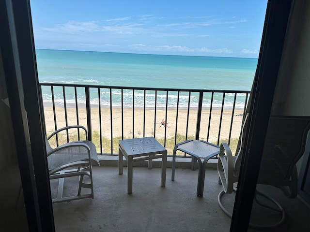 balcony featuring a beach view and a water view