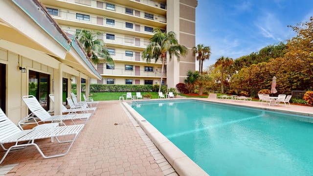 view of pool with a lawn and a patio