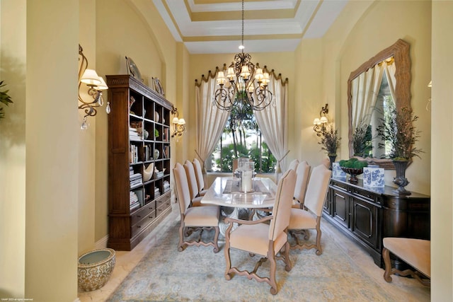 dining room with an inviting chandelier, a raised ceiling, crown molding, and light tile floors