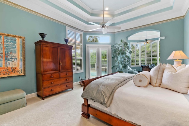 bedroom featuring french doors, ornamental molding, access to outside, and a tray ceiling