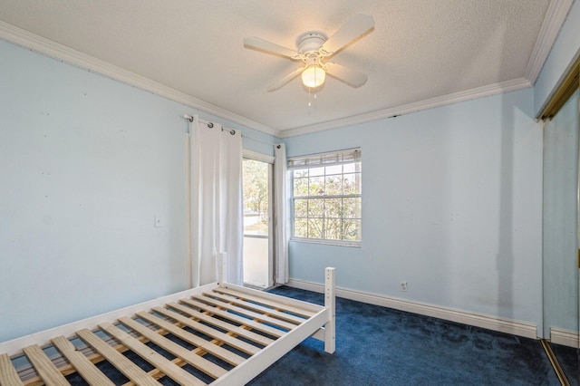 unfurnished bedroom featuring a textured ceiling, dark carpet, ceiling fan, and ornamental molding