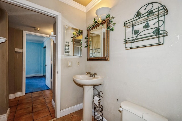 bathroom featuring crown molding, toilet, sink, and tile flooring