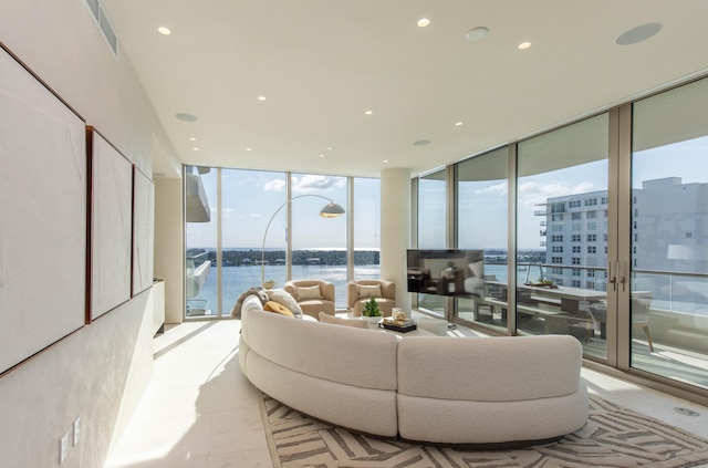 living room with a water view and a wall of windows