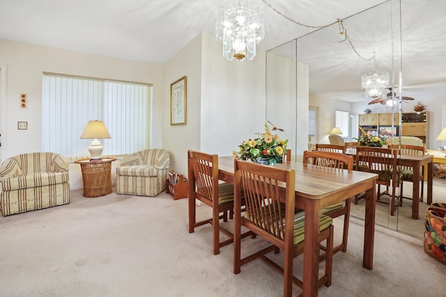 dining space with carpet and ceiling fan with notable chandelier