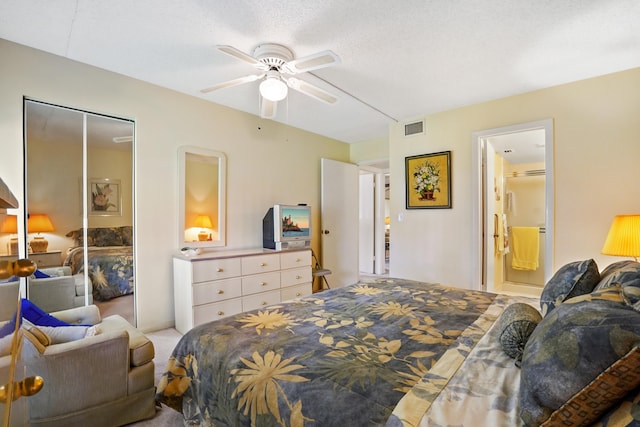 bedroom with ensuite bath, ceiling fan, light colored carpet, a textured ceiling, and a closet