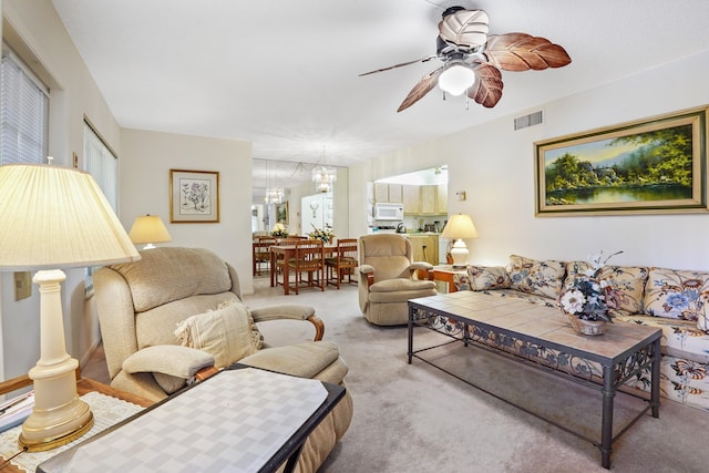 carpeted living room with ceiling fan