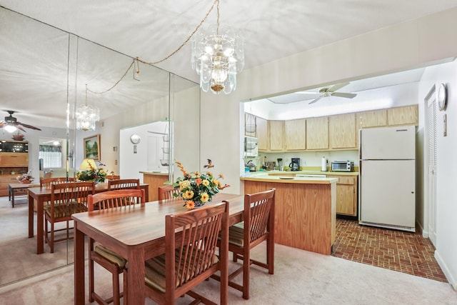 dining area featuring ceiling fan with notable chandelier and carpet floors