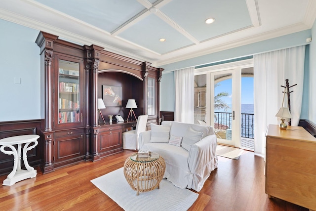 living room with ornamental molding, coffered ceiling, french doors, and light wood-type flooring