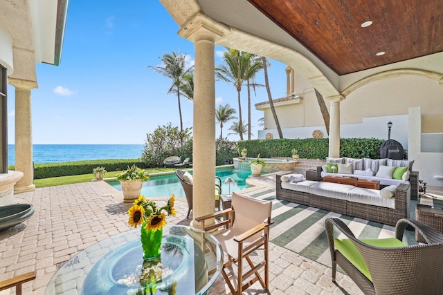 view of terrace with an outdoor living space and a water view