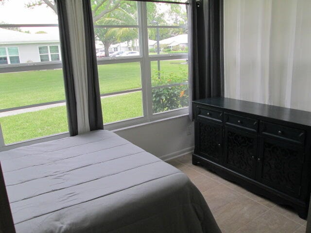 bedroom featuring multiple windows and light tile floors