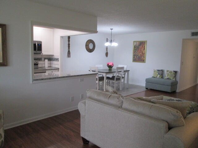 living room with a notable chandelier and dark hardwood / wood-style floors