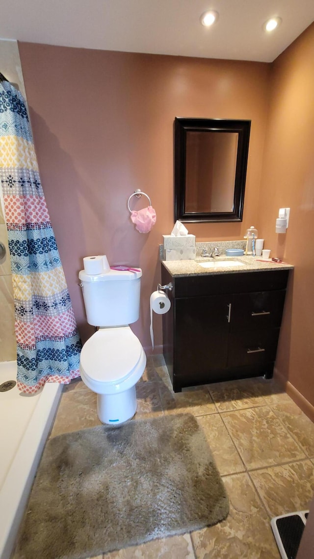 bathroom with toilet, tile floors, and vanity