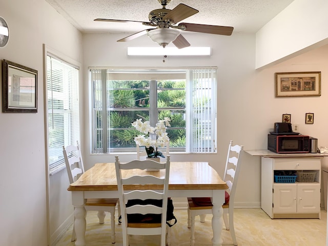 dining room featuring ceiling fan and a textured ceiling