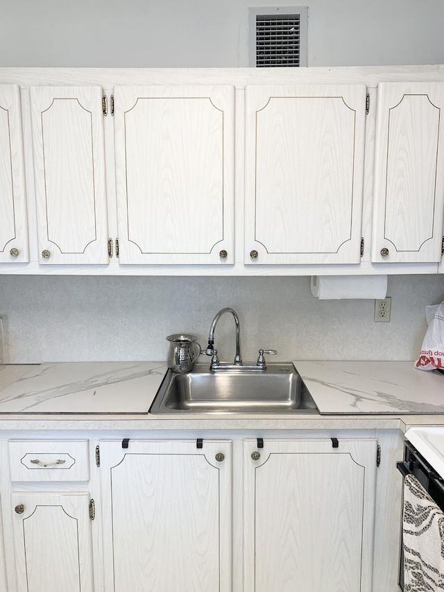 kitchen featuring sink and white cabinetry