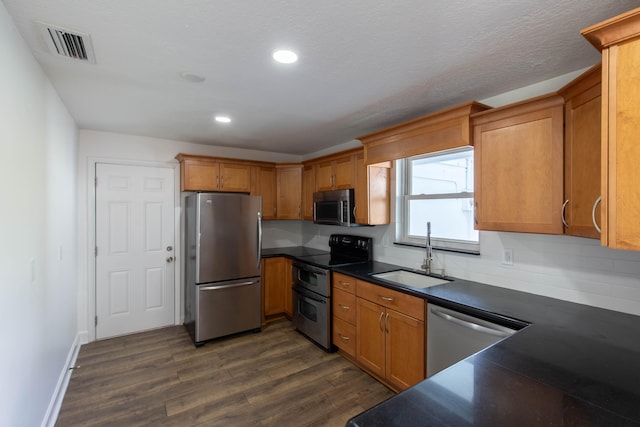 kitchen featuring backsplash, dark wood-type flooring, appliances with stainless steel finishes, and sink