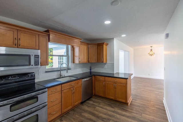 kitchen featuring backsplash, appliances with stainless steel finishes, dark wood-type flooring, and sink