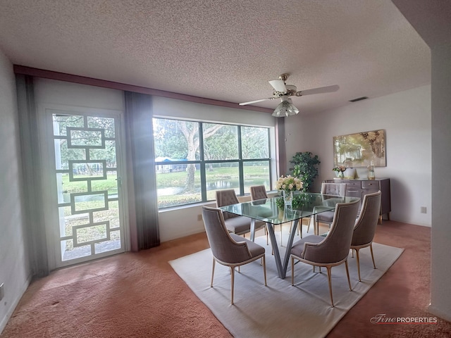 dining area with ceiling fan, a textured ceiling, and carpet flooring