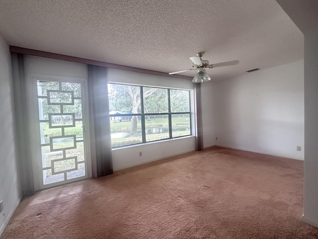 carpeted empty room with a textured ceiling and ceiling fan