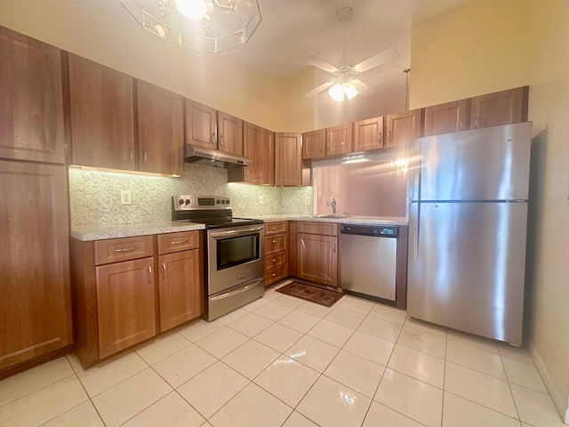 kitchen with tasteful backsplash, sink, appliances with stainless steel finishes, high vaulted ceiling, and light tile patterned floors