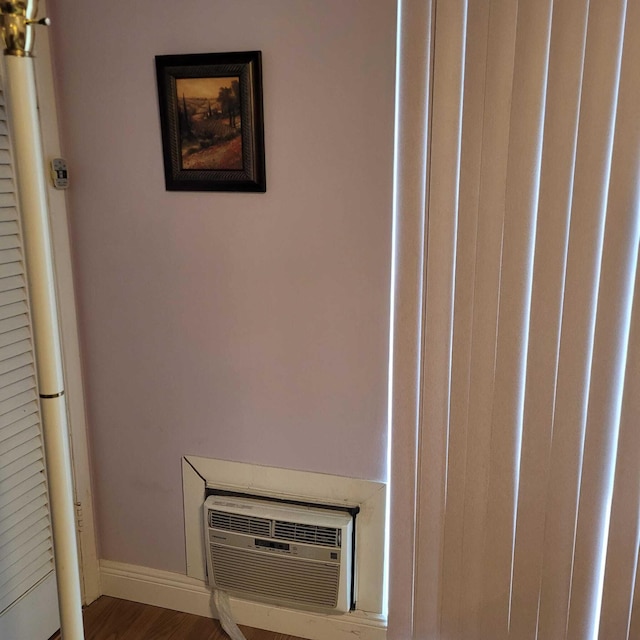 room details featuring dark wood-type flooring and a wall unit AC