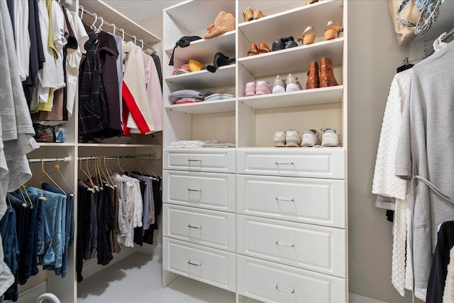 walk in closet with light tile flooring