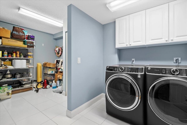 laundry area featuring hookup for an electric dryer, light tile flooring, independent washer and dryer, and cabinets