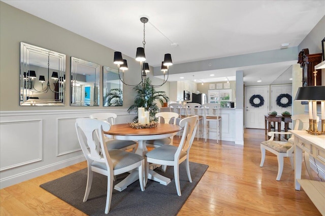 dining space featuring an inviting chandelier and light hardwood / wood-style floors