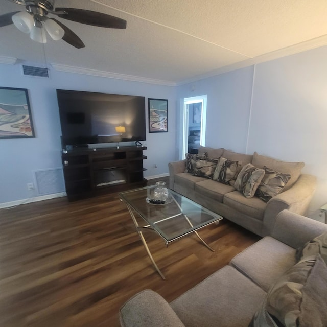 living room with ceiling fan, a textured ceiling, crown molding, and dark wood-type flooring