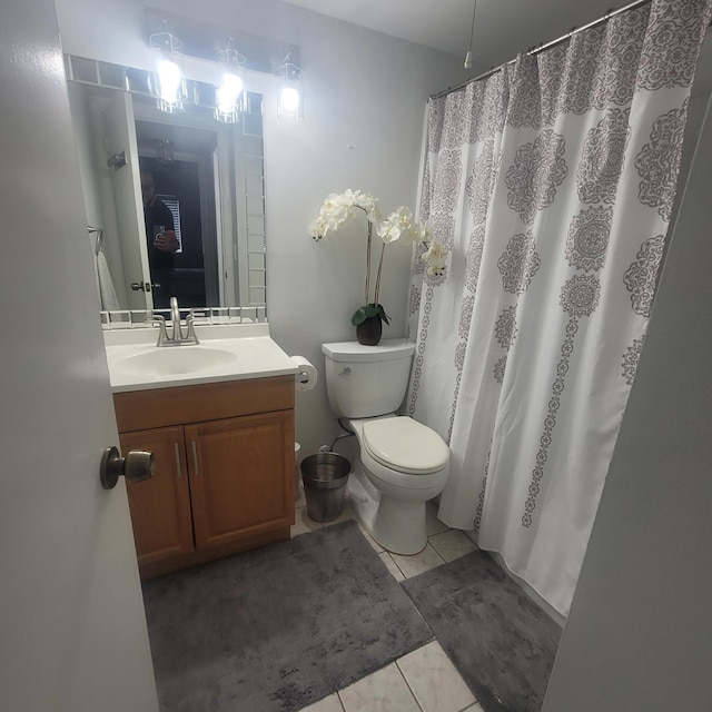 bathroom featuring toilet, tile floors, and vanity