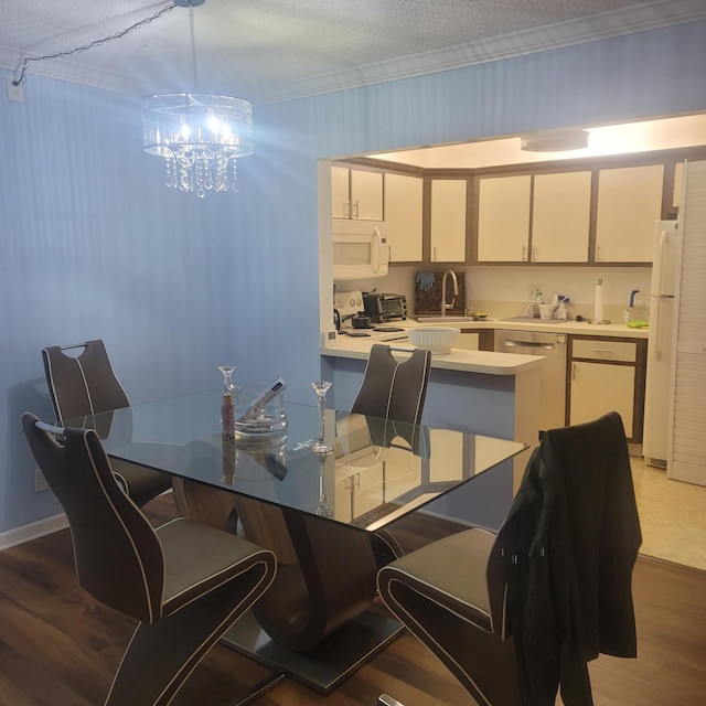 dining area with sink, light hardwood / wood-style flooring, a textured ceiling, and an inviting chandelier