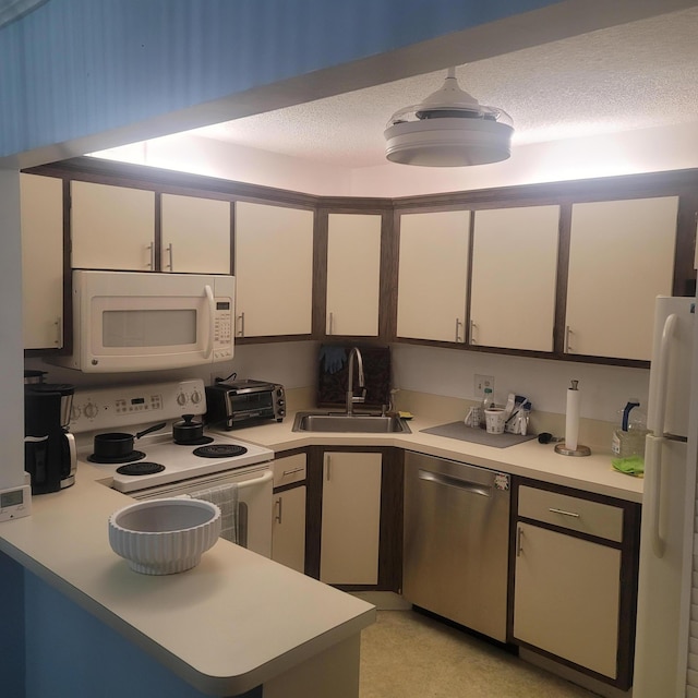 kitchen with white appliances, a textured ceiling, sink, and white cabinetry