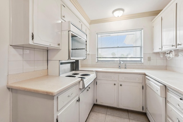 kitchen featuring white dishwasher, white cabinets, sink, and backsplash