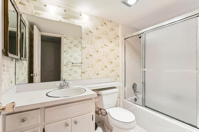 full bathroom with combined bath / shower with glass door, toilet, vanity with extensive cabinet space, and tile flooring