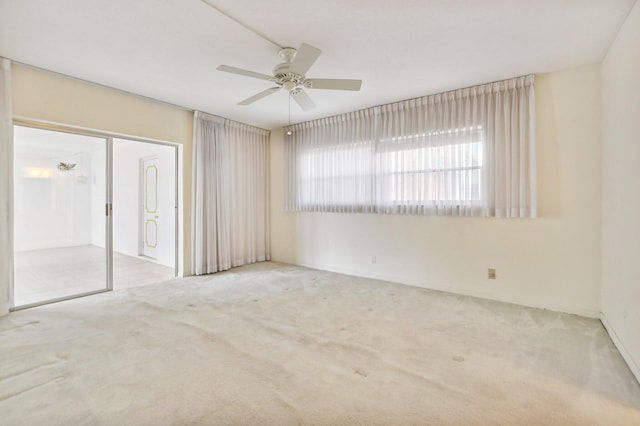 carpeted spare room with ceiling fan