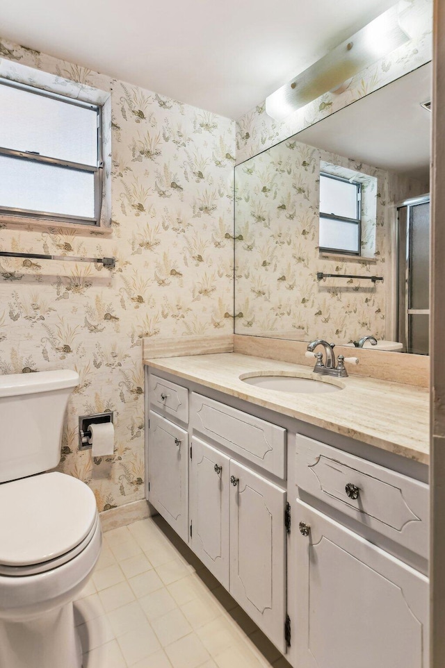 bathroom featuring toilet, tile floors, and vanity