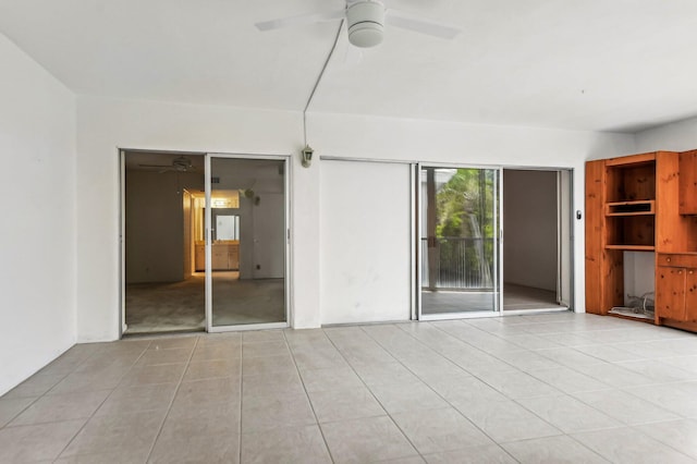 spare room featuring light tile flooring and ceiling fan