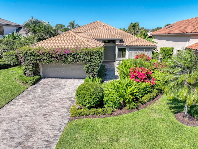 mediterranean / spanish-style house with a front yard and a garage