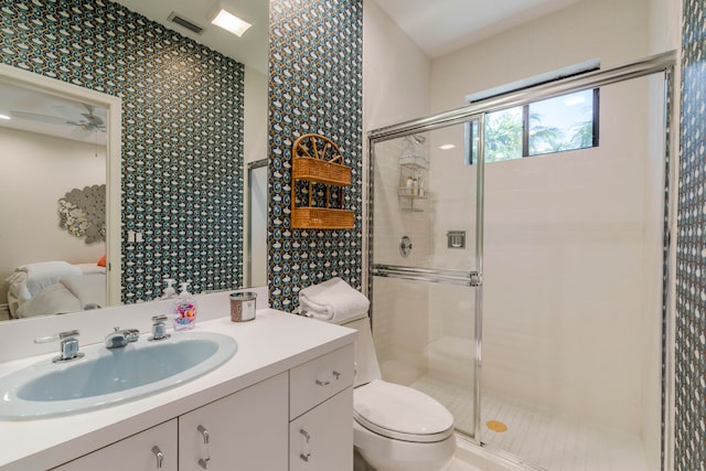 bathroom featuring an enclosed shower, toilet, vanity, and ceiling fan