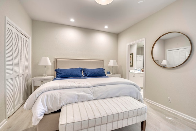 bedroom featuring a closet, ensuite bathroom, and light hardwood / wood-style flooring