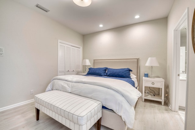 bedroom with light hardwood / wood-style floors and a closet