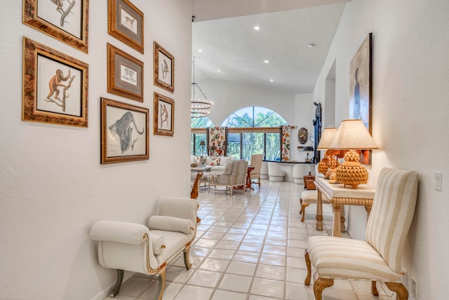 sitting room with high vaulted ceiling, a notable chandelier, and light tile floors