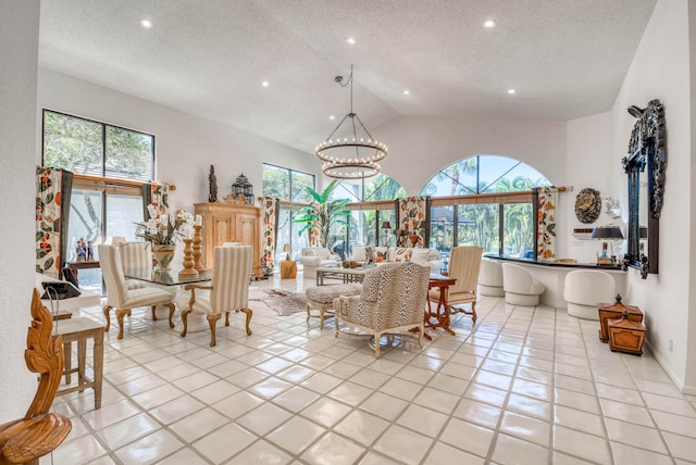 dining area with high vaulted ceiling, an inviting chandelier, a textured ceiling, and light tile flooring